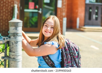 A Portrait Of Trisomy 21 Child Girl Outside On A School Playground