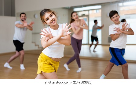 Portrait Of Tween Girl Doing Exercises During Family Class In Dance Center