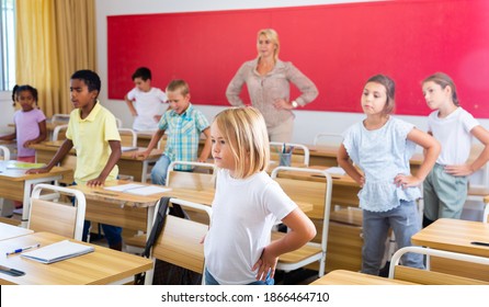 Portrait of tweens stretching with friendly female teacher during physical activity break in primary school - Powered by Shutterstock