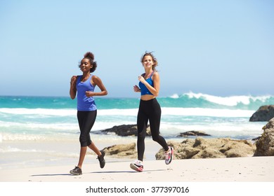 Portrait Of Two Active Young Women Running On The Beach 