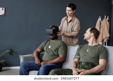 Portrait of two army veterans in therapy session with female psychotherapist using VR technology dealing with trauma and PTSD - Powered by Shutterstock