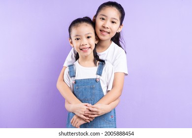 Portrait of two Asian girls on purple background
