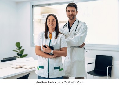 Portrait of two attractive doctors smiling while looking at camera standing in medical consultation. - Powered by Shutterstock