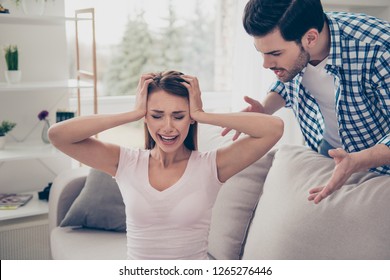 Portrait of two attractive sad worried nervous people married spouses husband wife breaking up having fight guy accusing dumping lady in white light interior room