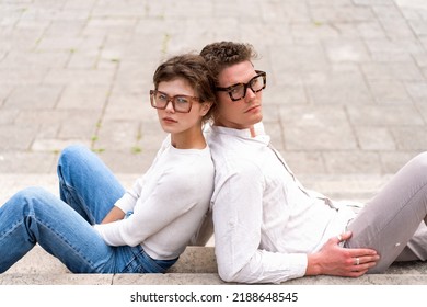 Portrait of two attractive students man and woman wearing stylish glasses sitting floor outdoor and smiling, head to head cheek to cheek, break relax between lesson, work, projects Eyeglasses concept - Shutterstock ID 2188648545