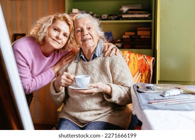 Portrait of two attractive women elderly mother and her mature daughter hugging together and looking at camera. Different generation, caregiver, authentic moment concept. - Powered by Shutterstock