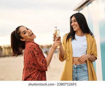 Portrait of two beautiful cheerful young women having fun drinking beer and toasting  on the beach. Laughing girlfriends in the sea side having fun
 - Powered by Shutterstock