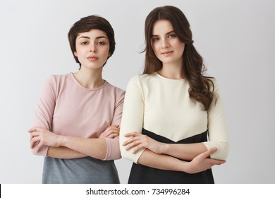 Portrait Of Two Beautiful Female University Friends With Dark Hair, Posing For Graduation Photo Album In Fashionable Clothes.