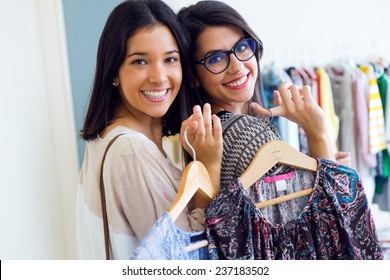 Portrait Of Two Beautiful Girls Shopping In A Clothes Shop.