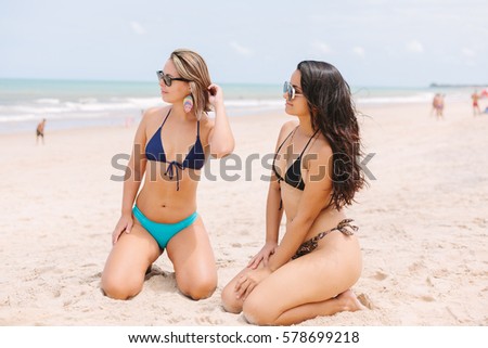 Portrait of two beautiful women having fun on the beach