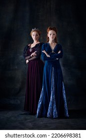 Portrait Of Two Beautiful Women In Image Of Queen And Princess Isolated Over Dark Background. Royal Family. Concept Of Comparison Of Eras, Modernity And Renaissance, Baroque Style, Beauty, History