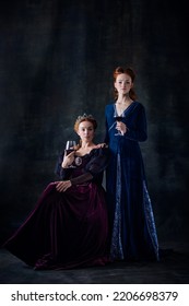 Portrait Of Two Beautiful Women, Royal Family Representatives, Queen And Princess, Isolated On Dark Background. Concept Of Comparison Of Eras, Modernity And Renaissance, Baroque Style, Beauty, History