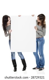 Portrait Of Two Beautiful Young Women Holding A Blank Notecard.