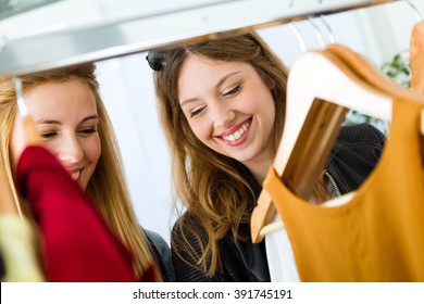 Portrait Of Two Beautiful Young Women Shopping In A Clothes Shop.