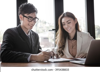 Portrait Of Two Business People Discussing New Project In Coffee Shop