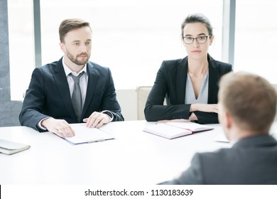 Portrait Of Two Business People, Man And Woman,  Talking To Partner Sitting Across Meeting Table In Conference Room, Copy Space