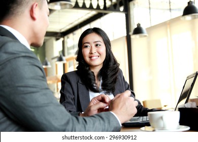 Portrait Of Two Business People Meeting At Cafe During Break Time At Cafetaria