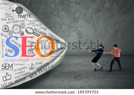 Portrait of two business people pulling SEO banner