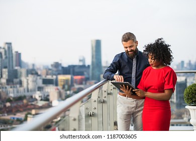 A portrait of two businesspeople standing against London view panorama. - Powered by Shutterstock