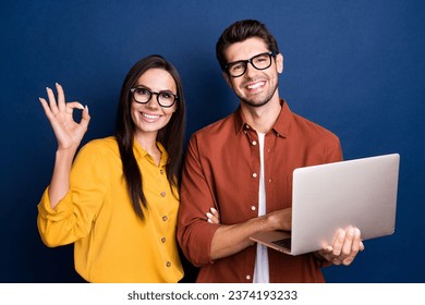 Portrait of two businesspeople use netbook demonstrate okey approve symbol isolated on blue color background - Powered by Shutterstock