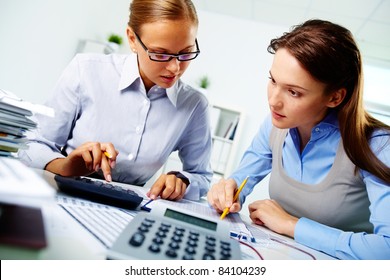 Portrait of two businesswomen working with papers in office
