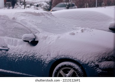 A Portrait Of Two Cars Parked In A Driveway Covered In White Snow During Winter. The Driver Will Have To Clear The Windows Before Driving Or Will Have To Wait For The Snow To Melt.