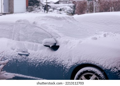 A Portrait Of Two Cars Parked In A Driveway Covered In White Snow During Winter Season. The Driver Will Have To Clear The Windows Before Driving Or Will Have To Wait For The Snow To Melt.