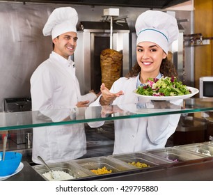 Portrait Of Two Cheerful Friendly Hospitable Chefs With Kebab At Fast Food Place