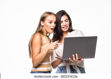 Portrait Of Two Cheerful Women Looking At The Laptop Over White Background.