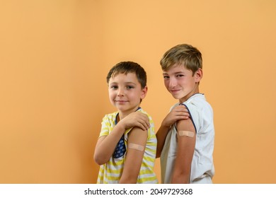 Portrait Of Two Children Showing Their Arm With A Band Aid. Vaccine Concept