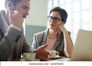 Portrait Of Two Confused Business People, Man And Woman, Solving Work Problem During Meeting In Cafe