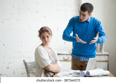 Portrait Of Two Coworkers Arguing At Work. Staff In The Middle Of Argument At Modern Office. Young Furious Man Yelling At Annoyed Stressed Woman With Crossed Arms. Negative Human Emotions