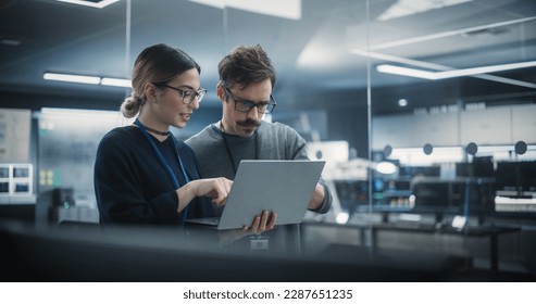 Portrait of Two Creative Young Female and Male Engineers Using Laptop Computer to Analyze and Discuss How to Proceed with the Artificial Intelligence Software. Standing in High Tech Research Office - Shutterstock ID 2287651235