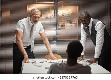 Portrait of two detectives interrogating suspect in criminal case, copy space