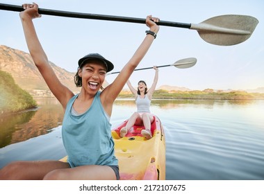 Portrait two diverse young woman cheering and celebrating while canoeing on a lake. Excited friends enjoying rowing and kayaking on a river while on holiday or vacation. Winning on a weekend getaway - Shutterstock ID 2172107675