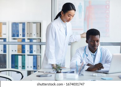 Portrait Of Two Ethnic Young Doctors Using Laptop In Med School Or Internship, Copy Space