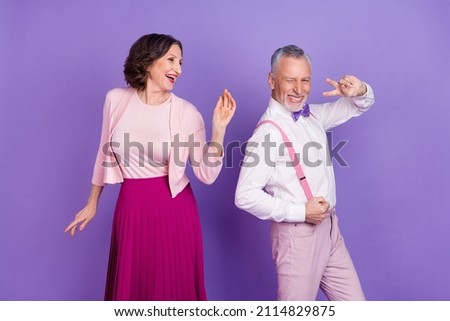 Portrait of two excited funky people enjoy discotheque event isolated on violet color background