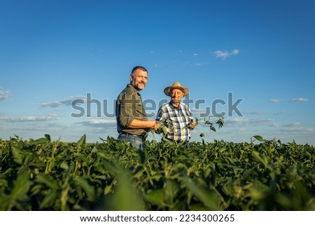 Portrait of two farmers in a soy field.