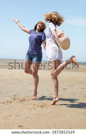 portrait of two female friends walking on the sea shore
