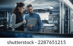 Portrait of Two Female and Male Engineers Using Laptop Computer to Analyze and Discuss How to Proceed with the Artificial Intelligence Software. Casually Chatting in High Tech Research Office