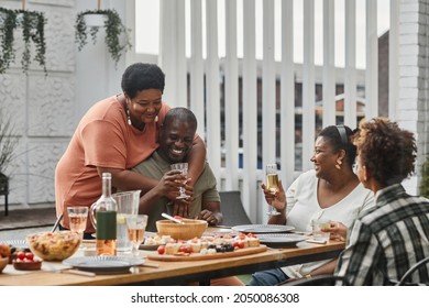 Portrait of two generation African-American family enjoying dinner together with senior couple embracing in foreground, copy space - Powered by Shutterstock