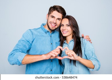 portrait of two happy smiling  lovers making heart with fingers.