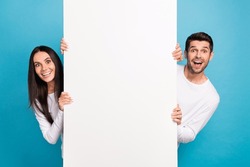 Portrait Of Two Impressed Positive People Peek Behind Empty Space Blank Isolated On Blue Color Background