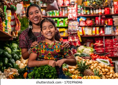 Portrait of two indigenous girls looking at the camera, in a grocery store in Guatemala.