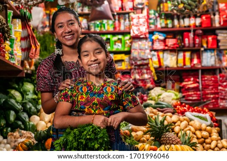 
Portrait of two indigenous girls looking at the camera, in a grocery store in Guatemala.