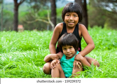 Portrait Of Two Latin American Sisters Outdoors.