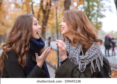 Portrait of a two laughing women talking outdoors in autumn park - Shutterstock ID 339695138