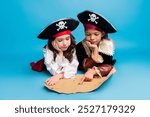 Portrait of two little kids point finger treasure map halloween pirate costume isolated on blue color background