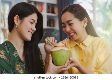 Portrait Of Two Long-haired Asian Friends Drinking Sweetened Fresh Coconut Water Together, Organic Fruit : Happiness In The House, Natural Fruit Juices, The Two Of Them Vie For Drinks With Smiles