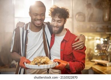 Portrait of two lovely multiracial guys standing together with cooked turkey on kitchen with a steam on background from the oven. Concept of gay relations everyday life together at home - Powered by Shutterstock